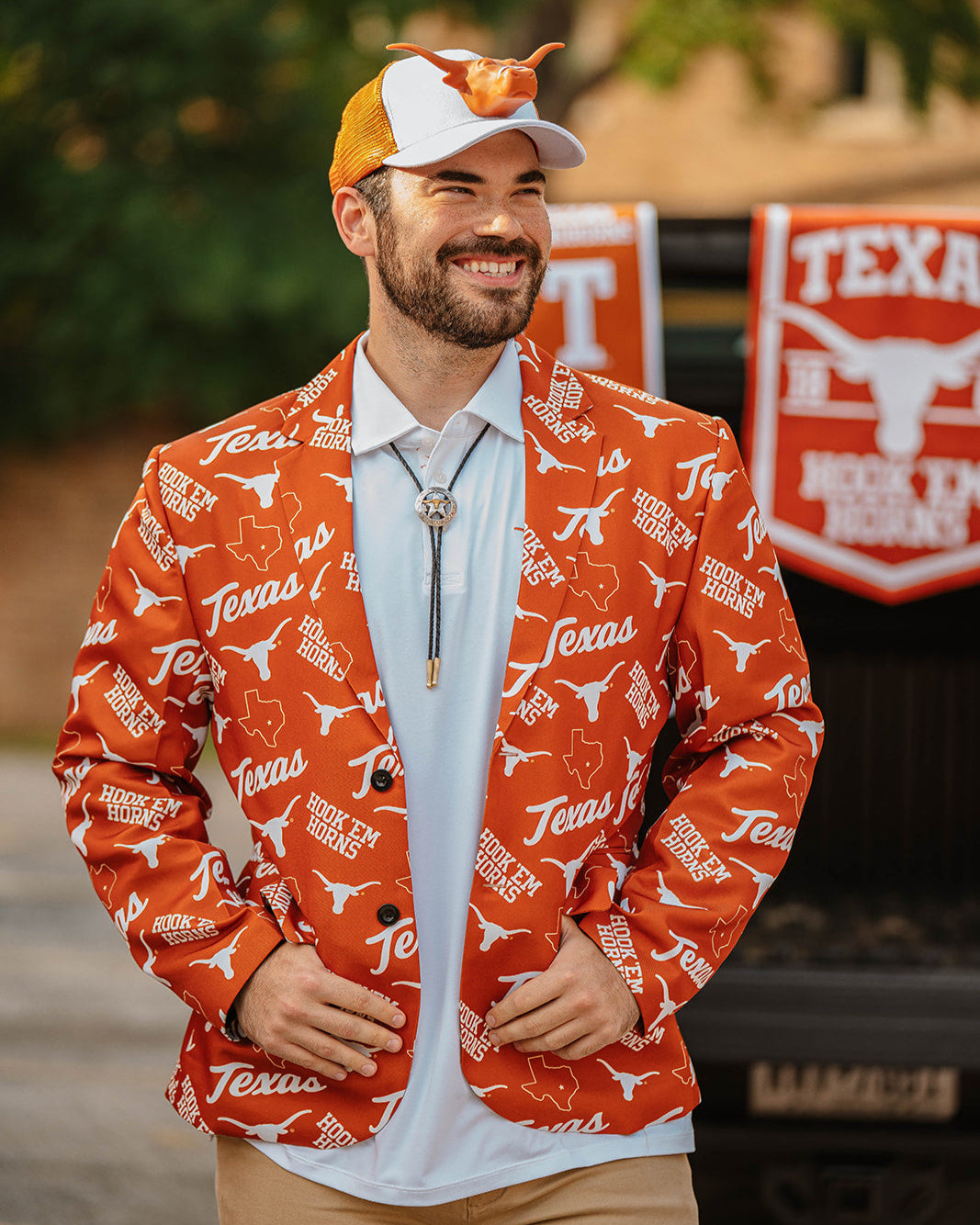 Longhorn fan wearing a burnt orange men's blazer with pattern of Texas script, Longhorn, and Hook 'Em Horns