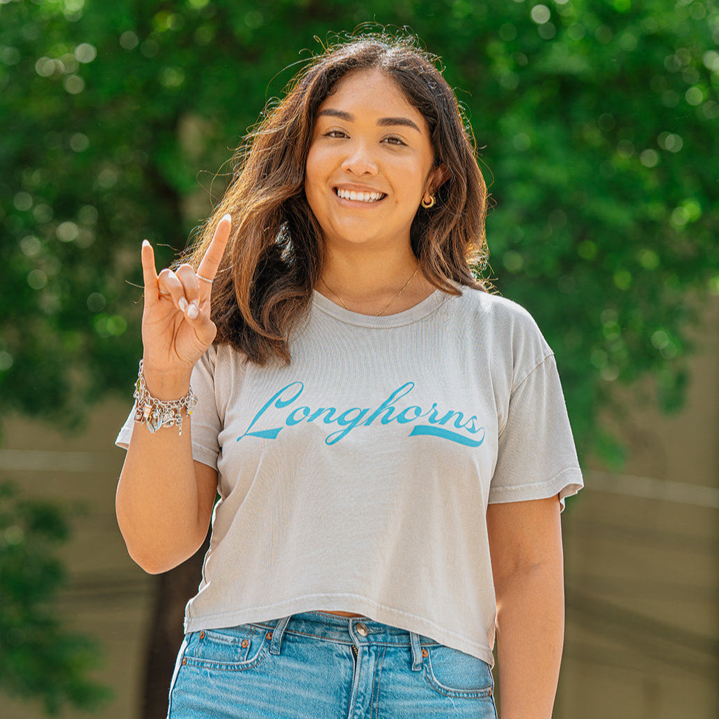 College woman wearing Texas Longhorns crop tee
