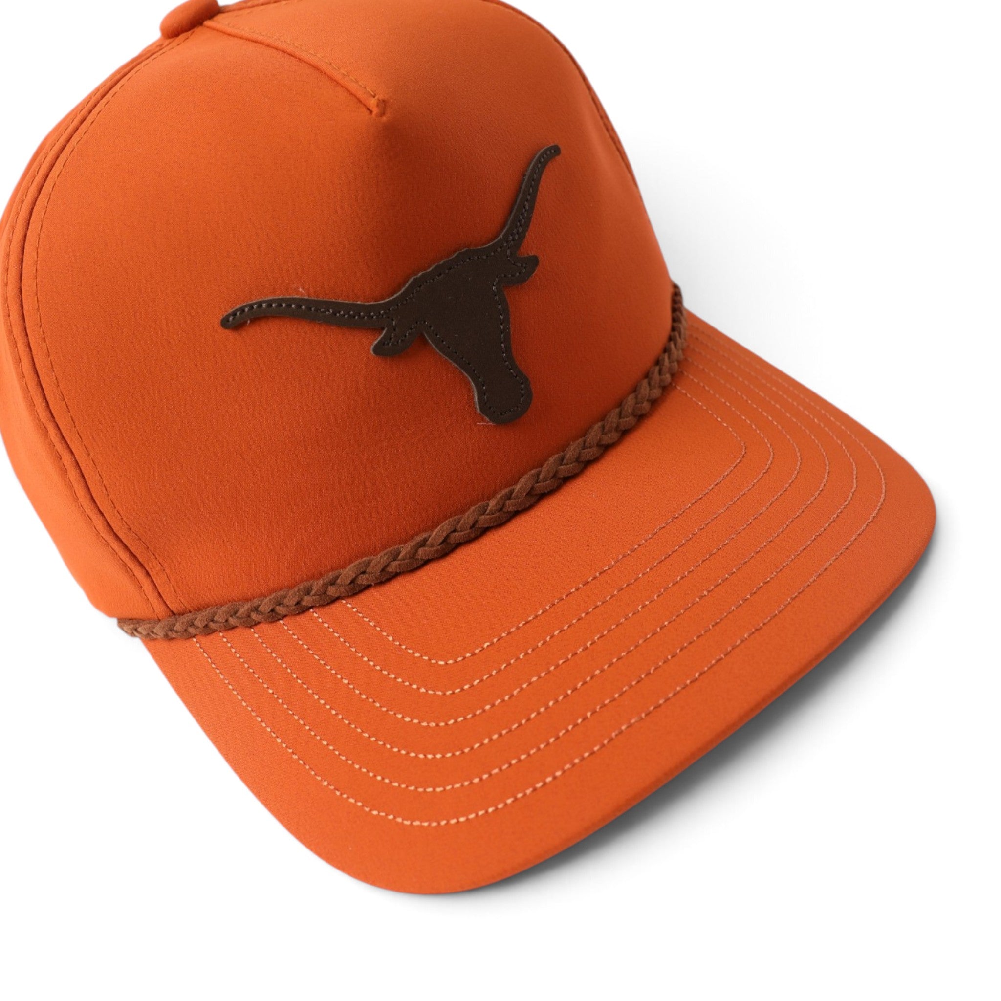 An orange baseball cap featuring a dark brown leather Texas Longhorns logo patch on the front, a brown braided rope detail around the crown, and white contrast stitching on the brim, shown against a plain white background.