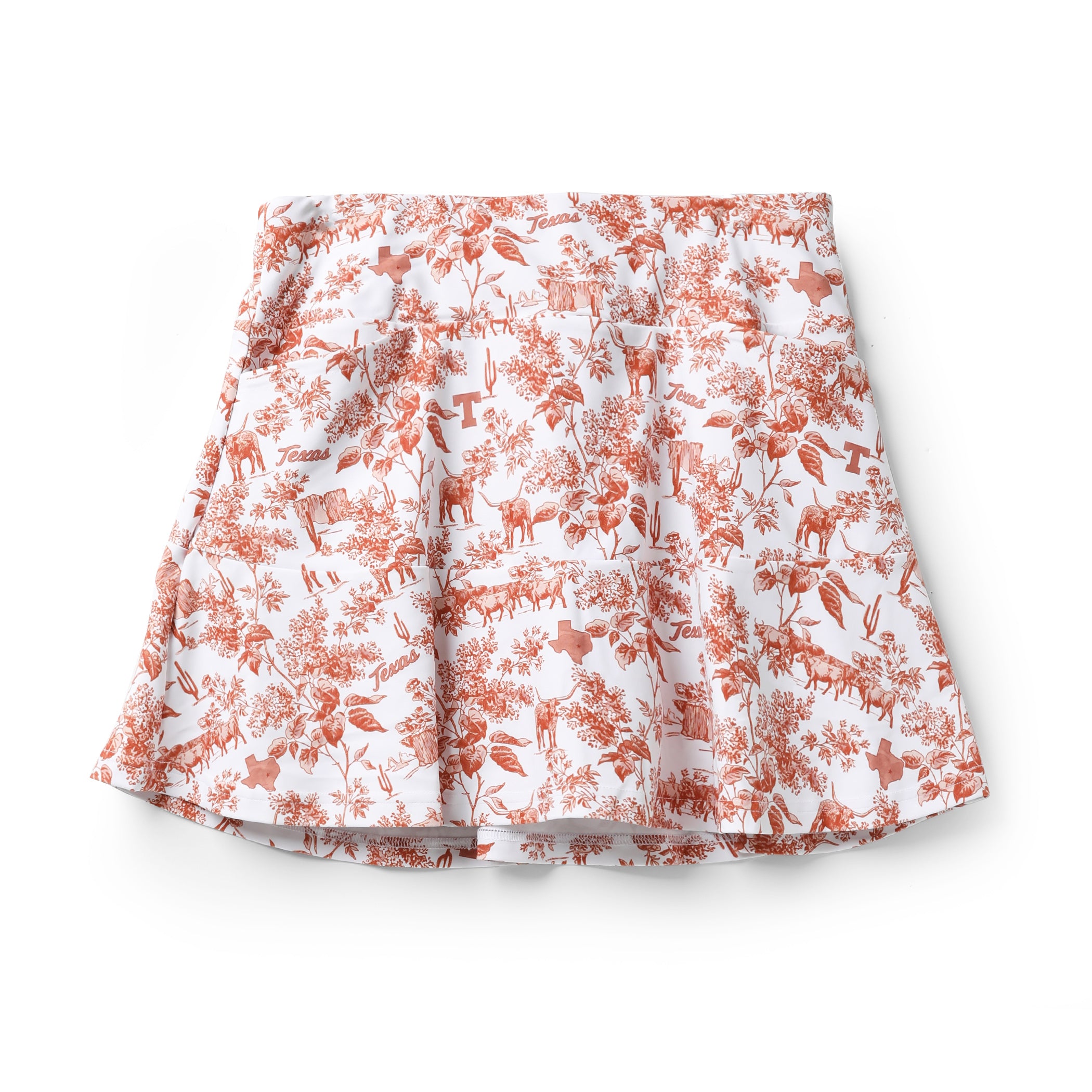 A white pleated skirt with an all-over terracotta orange toile-style print featuring deer, birds, and floral motifs, shown flat against a white background.