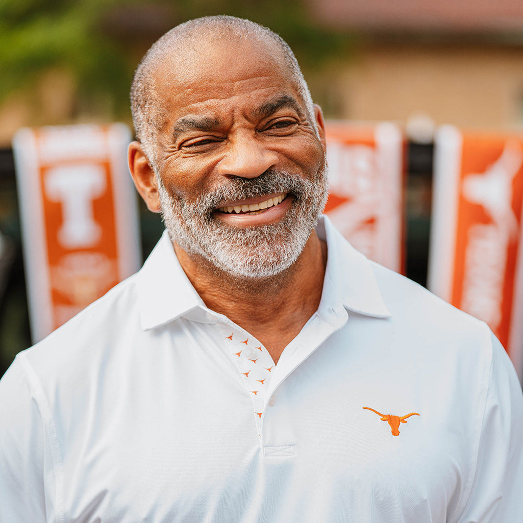 Gentleman wearing white University of Texas Longhorns polo from B. Draddy
