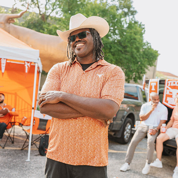 Man wearing burnt orange Texas Longhorn tailgate polo with cowboy hat