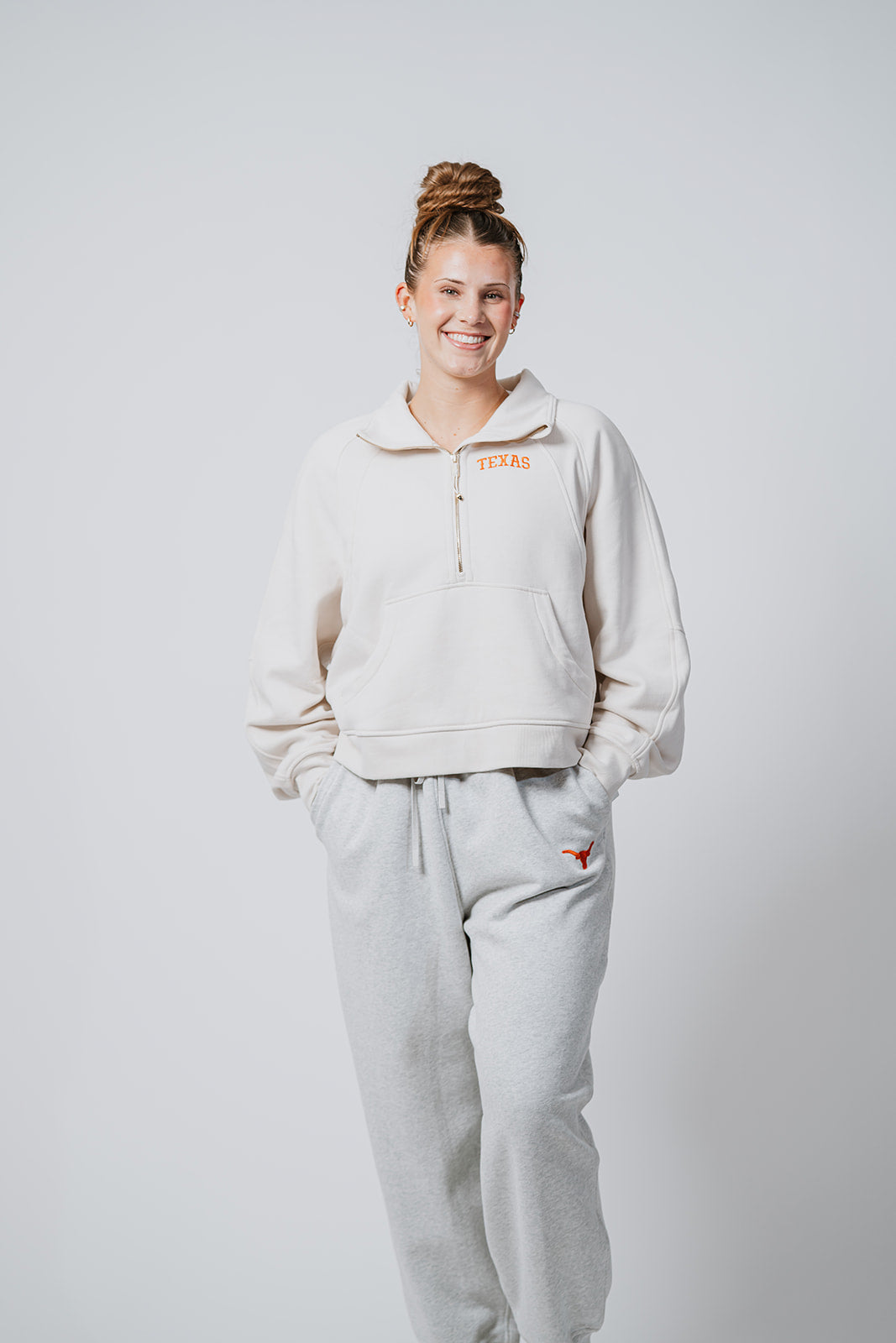 Longhorn wearing a beige hoodie and gray sweatpants on a white background. Longhorn merch lululemon