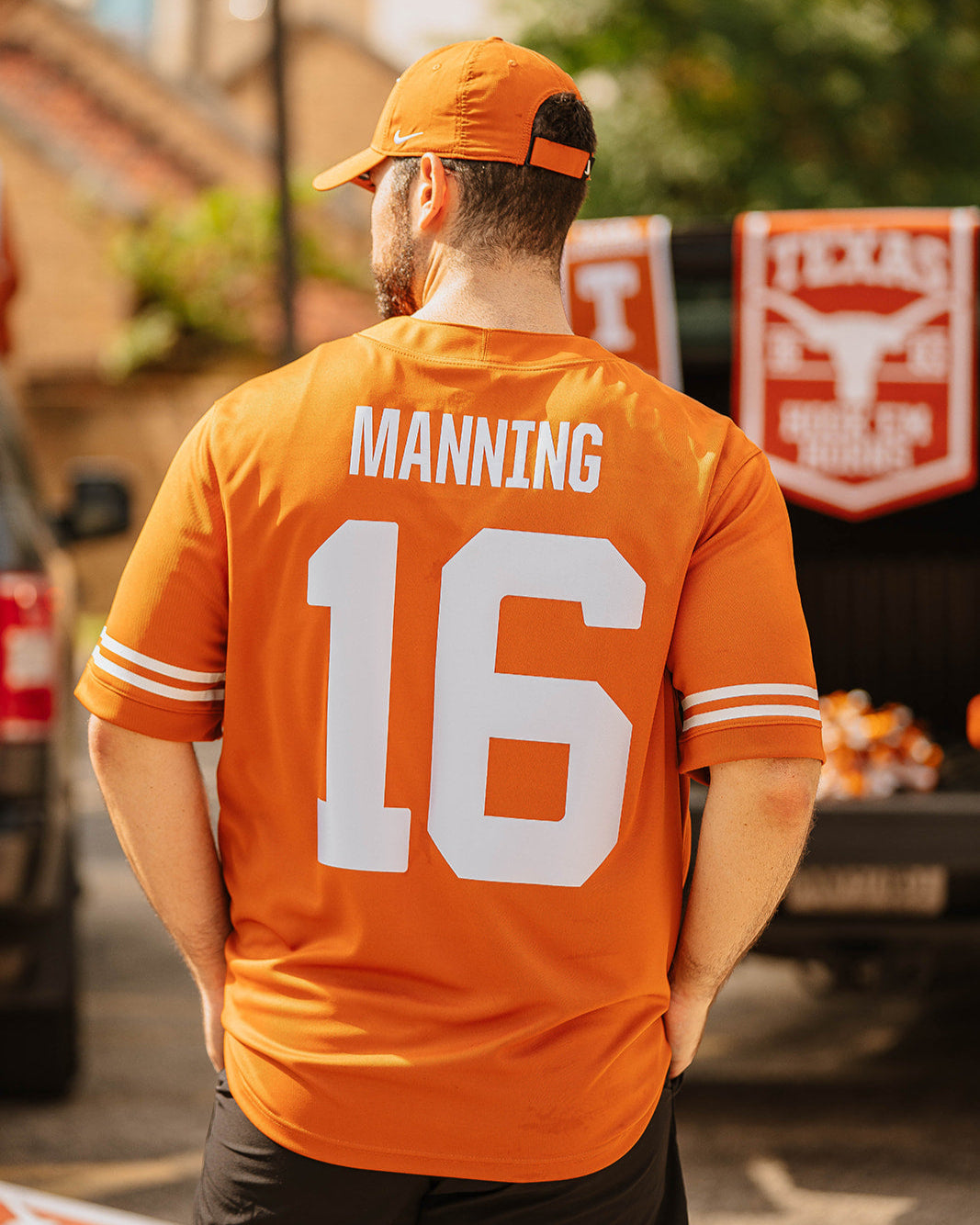 Person wearing a burnt orange football jersey with 'Manning 16' on the back, standing outdoors.