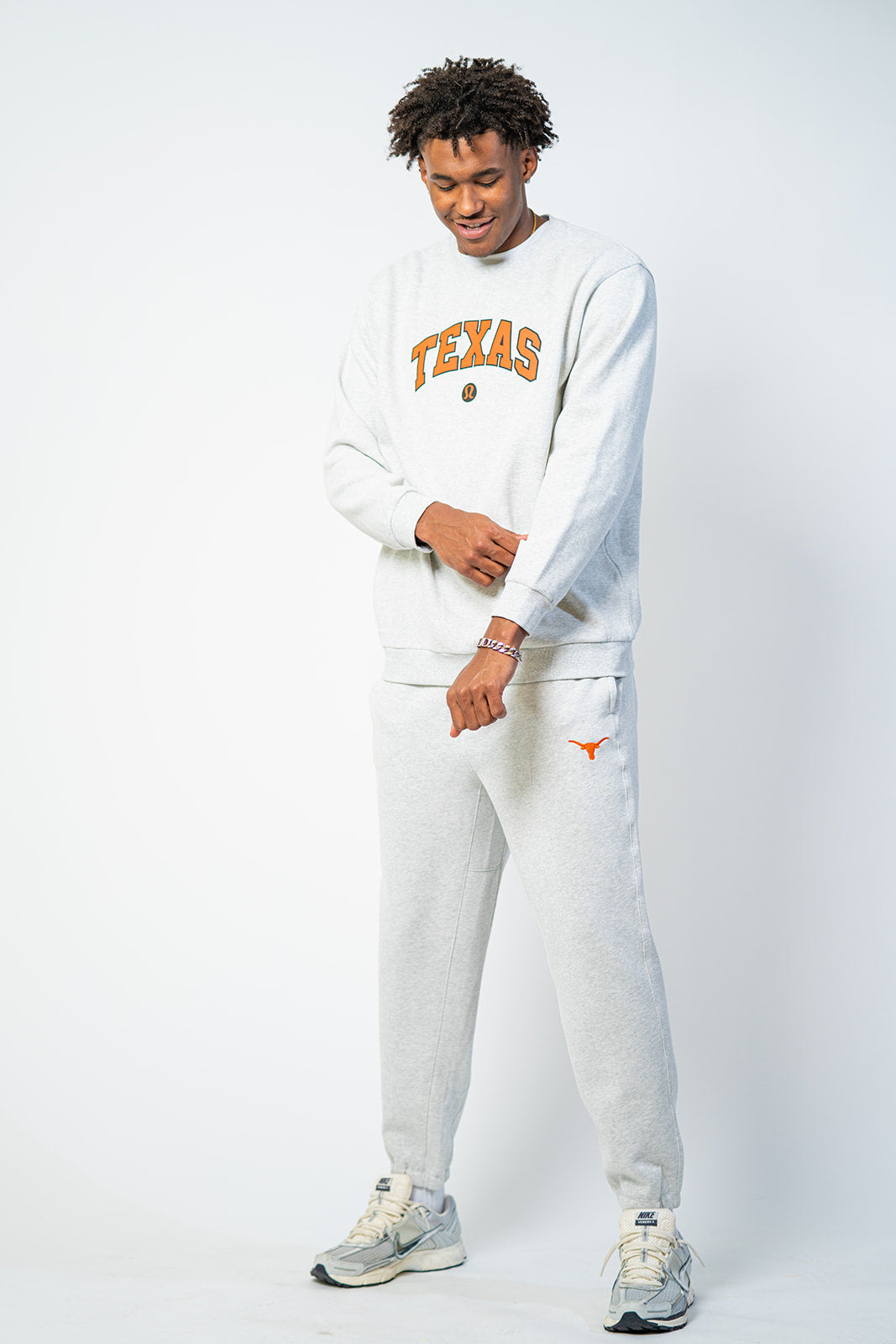 Longhorn wearing a white lululemon 'Texas' sweatshirt and pants . Texas Longhorns merch