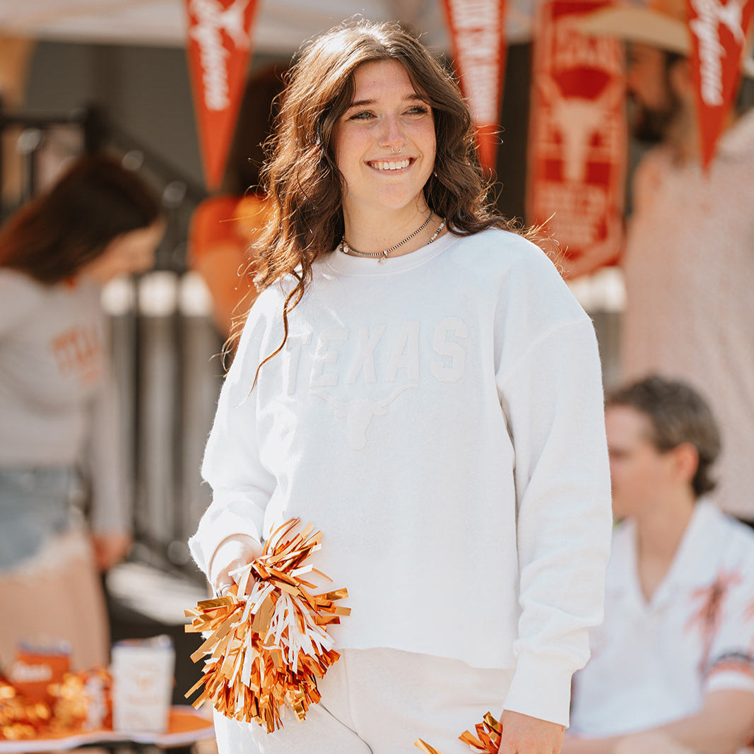 woman wearing white texas longhorns sweatshirt with white lettering