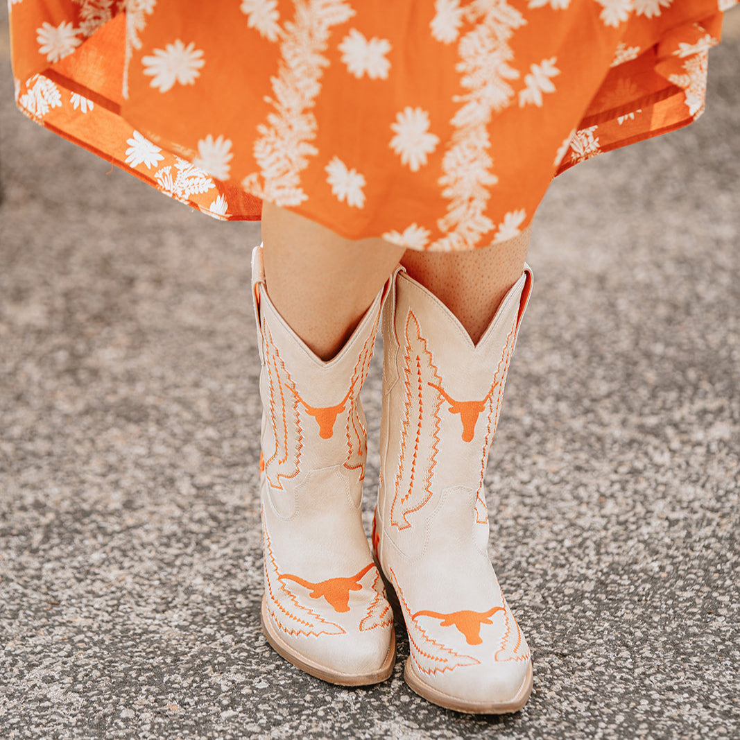 white cowboy boots with burnt orange stitched detailing that says hook 'em 