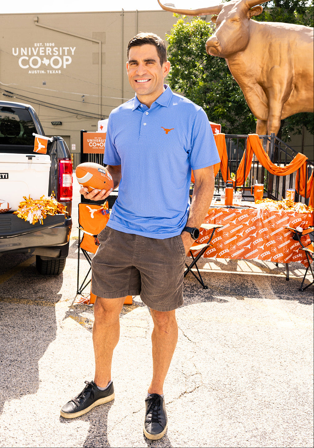 Longhorn fan at a tailgate wearing a longhorn polo top 