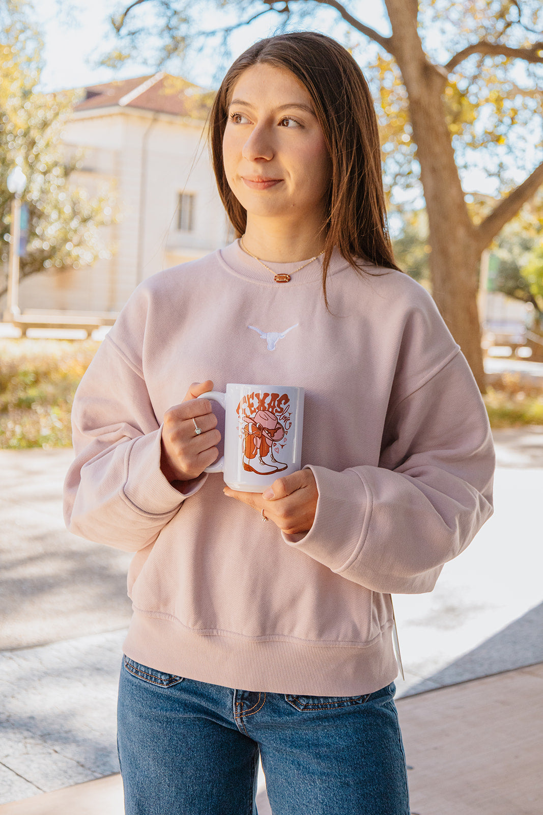 Woman holding a mug outdoors with a blurred background