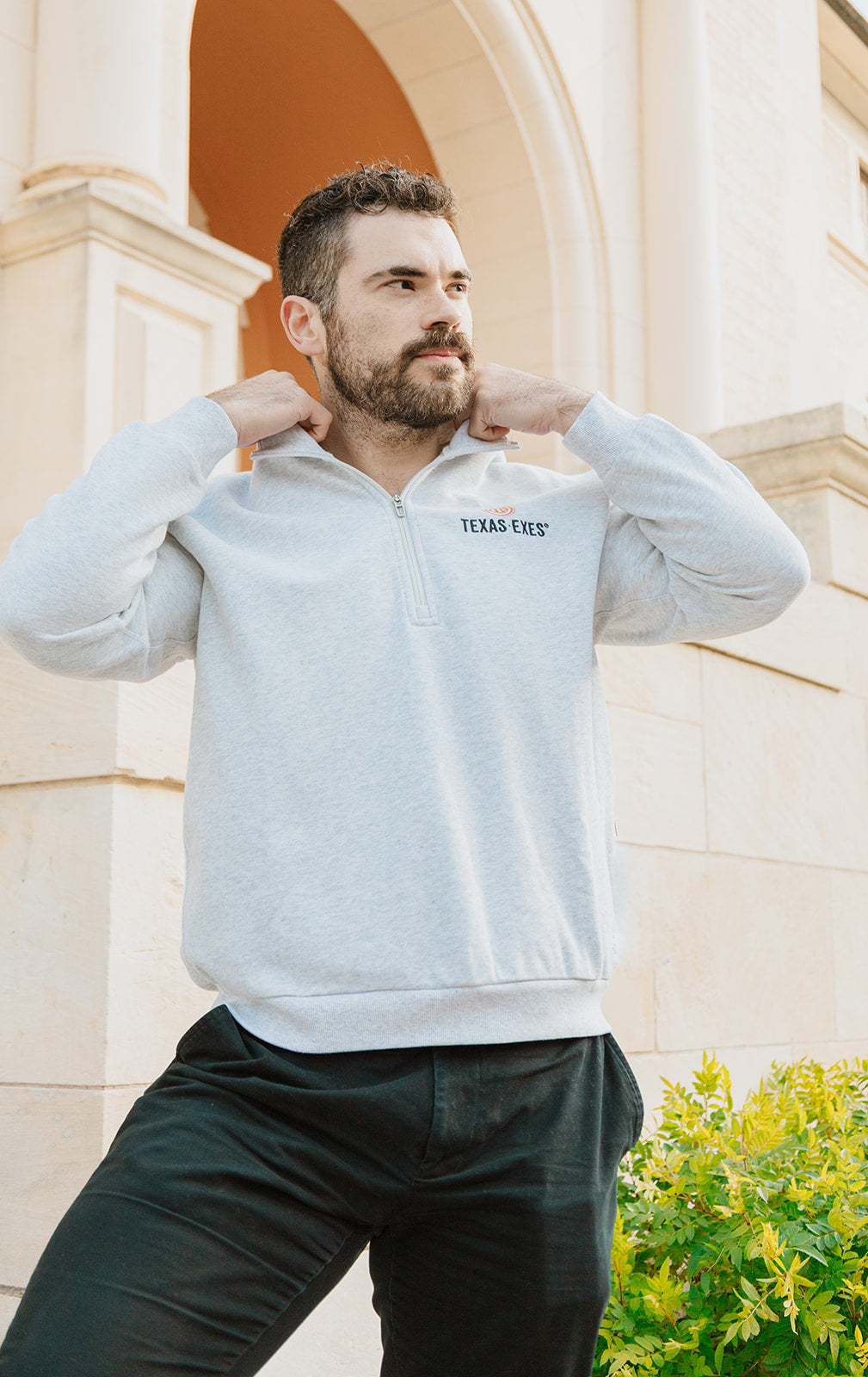 Man wearing a light gray sweatshirt with 'Texas Chef' logo outdoors.