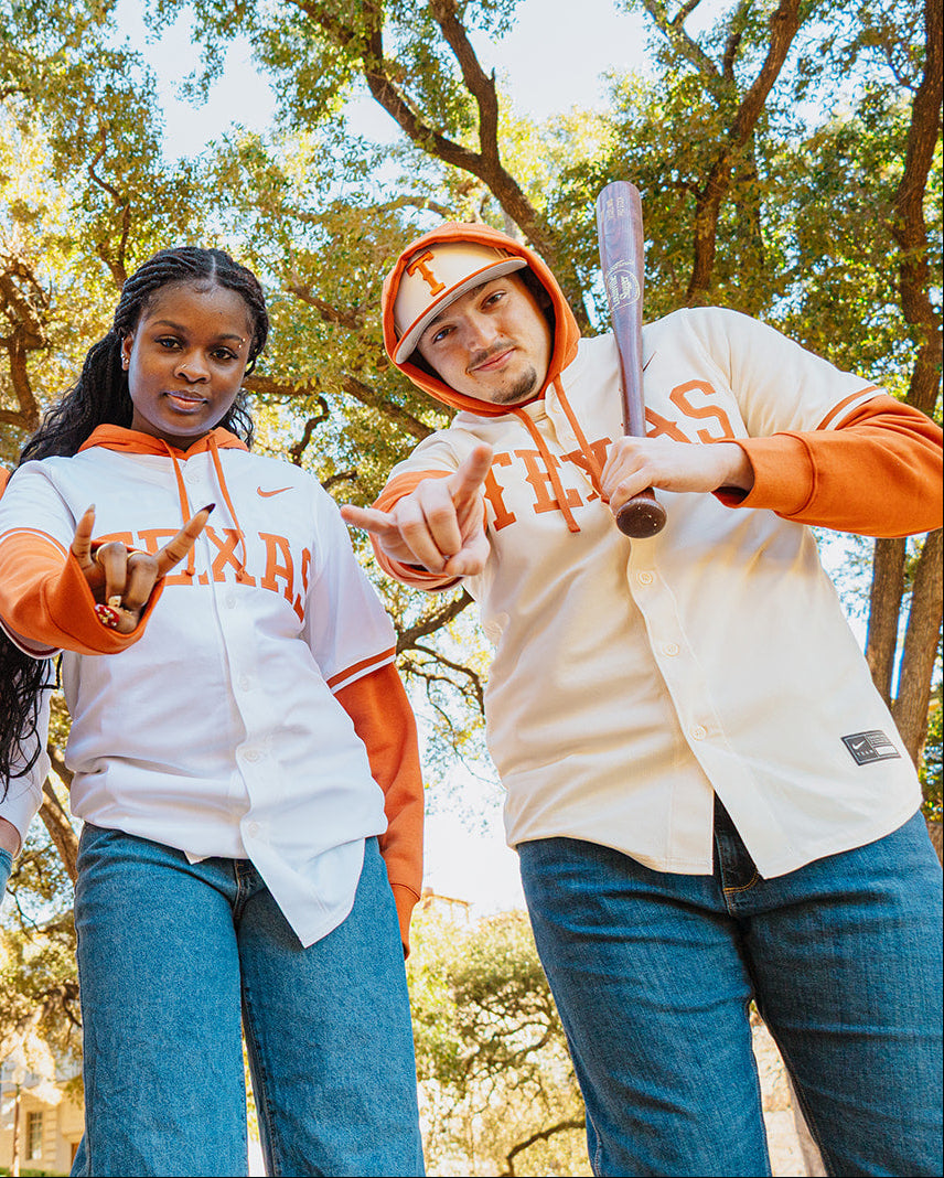 Four friends wearing Texas-themed hoodies outdoors with trees in the background