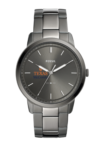 Fossil wristwatch with a round stainless steel case and matching metal link bracelet, featuring a dark gray dial with silver hour markers and hands. The dial includes the Fossil brand name and a Texas McCormick logo.